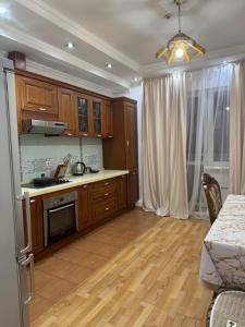 a kitchen with wooden cabinets and a counter top at spacious apartment in Almaty