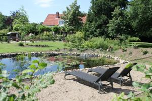 a picnic table and two chairs in front of a pond at Boutique Hotel Nieuw Beusink in Winterswijk