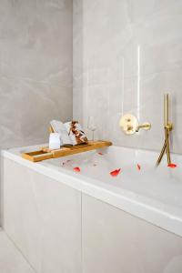 une salle de bain blanche avec une baignoire blanche et un lavabo blanc dans l'établissement Sia North Green, à Voluntari