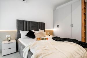 - une chambre avec un grand lit et des placards blancs dans l'établissement Sia North Green, à Voluntari