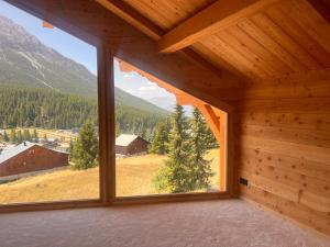 an empty room with a large window in a cabin at Chalet les 3 Montagnards - 200m des pistes in Montgenèvre