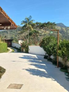 a pathway with trees and a wall and a mountain at Pousada Canto Verde in Paraty