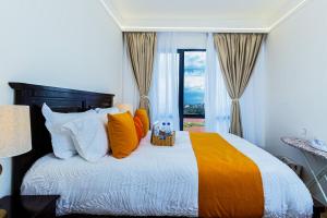 a bed with orange and white pillows and a window at Serene stays by Remi in Nairobi