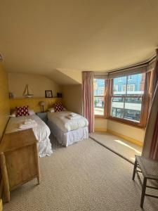 a bedroom with two beds and a large window at Pilots House Aldeburgh in Aldeburgh +6 photos
