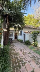 une maison avec un palmier et une passerelle en pierre dans l'établissement La Petite Maison San Isidro, à San Isidro