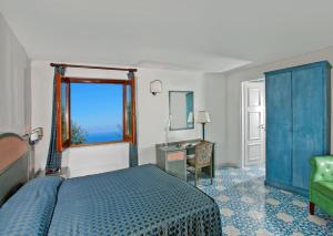 a bedroom with a bed and a window and a desk at Hotel Il Girasole in Anacapri