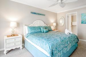 a bedroom with a blue bed with a blue comforter at A Gulf Front Getaway in Anna Maria Island +20 photos