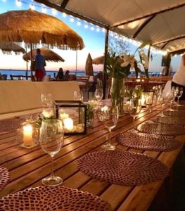 - une longue table en bois avec des verres à vin et des bougies dans l'établissement Exclusivo depto "Sea&Forest" frente mar P7 Mansa! parada 7 mansa - Punta del este, à Punta del Este