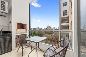 a balcony with a table and chairs and a large window at Monoambiente con Parrilla y Cochera - Dpto 402 in Asuncion