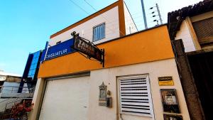 サンルイスにあるTanan Hostelのドアとバルコニーのあるオレンジと白の建物