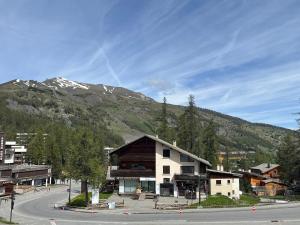a building on the side of a street with a mountain at appartement cocooning ski au pied in Vars