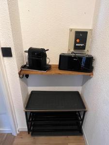 a shelf with a toaster and a printer on it at appartement cocooning ski au pied in Vars