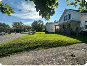 a white house on the side of a road at Cozy apartment Liverpool NY in Liverpool