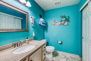 a blue bathroom with a sink and a toilet at Boardwalk Adventures in Long Beach +30 photos
