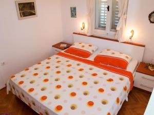 a bedroom with a large bed with orange pillows at Apartment Petricic in Postira