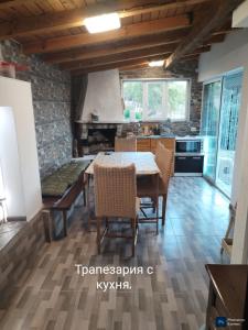 a kitchen with a table and chairs in a room at Вила "до Гората" in Zărkwischte
