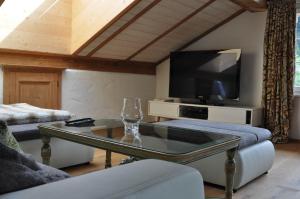 a living room with a tv and a glass table at Appartement Kitzbühel mit Dachterrasse in Kitzbühel