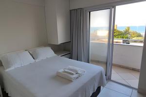 a bedroom with a white bed and a large window at Apartamento praia Natal in Natal +27 photos