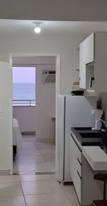 a white kitchen with a view of the ocean at Apartamento praia Natal in Natal