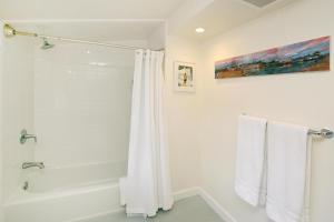 a bathroom with a shower and a white shower curtain at Riverhouse in Capitola +31 photos
