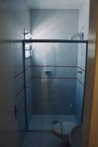 une salle de bain avec une douche en verre et des toilettes dans l'établissement Motel Del Fuego, à Pelotas