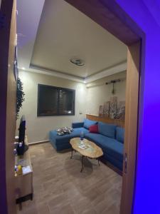 a living room with a blue couch and a table at Bel appartement in Casablanca