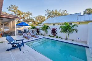 ein Swimmingpool mit Stühlen und ein Haus in der Unterkunft Downtown-Gulfport-Cooled & Heated Pool in St Petersburg
