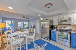 eine Küche mit blauen Schränken sowie einem weißen Tisch und Stühlen in der Unterkunft Downtown-Gulfport-Cooled & Heated Pool in St Petersburg