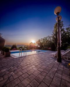 a villa with a swimming pool and a street light at Sky Resort in Gunjavci