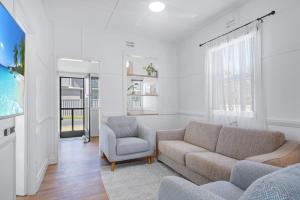 a living room with a couch and a chair at Little Street Retreat - Harrington in Harrington