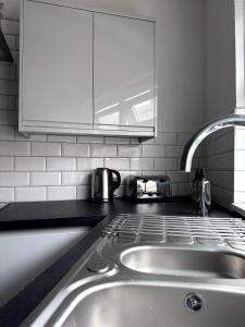 a kitchen counter with a sink and a microwave at Cosy Haus in Manchester