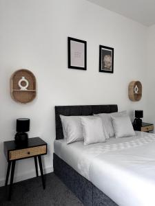 a white bedroom with a bed and a table at Cosy Haus in Manchester