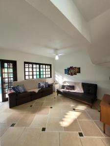 a living room with two couches and a table at Casa de condomínio em Boicucanga in Boicucanga