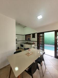 a kitchen and dining room with a table and chairs at Casa de condomínio em Boicucanga in Boicucanga