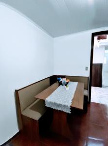 a table in a room with a white wall at Suíte Nosso Abrigo - Jaguaribe 2km do Capivari in Campos do Jordão +2 photos