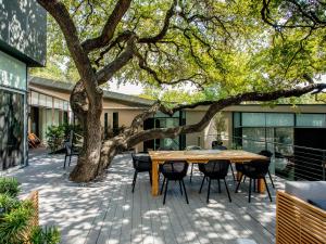 a table and chairs under a tree on a patio at Frame Hotel - Treehouse in Austin