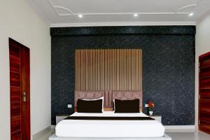 1 dormitorio con 1 cama grande y pared negra en Hotel O BGM, en Neemrana 26 fotos más