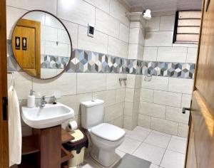 a bathroom with a toilet and a sink and a mirror at Alojamiento Bilbao in Quillacollo +30 photos