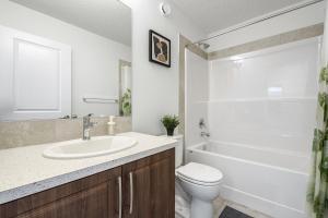 łazienka z umywalką, toaletą i wanną w obiekcie Quiet 3BR And 2 Bath Home In Calgary Near Airport w mieście Calgary +36 zdjęć