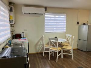 a kitchen with a table and chairs and a refrigerator at Cabaña in Coihaique