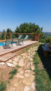 a group of benches sitting on a deck next to a pool at Casa de Cima - Sítio dos Henriques in Alfeizerão