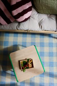 ein Holztablett mit einem Bild auf einem Bett in der Unterkunft Araça Studio - Atlantic Mountain Living in São Vicente + 9 Fotos