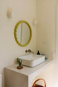 ein Badezimmer mit einem weißen Waschbecken und einem Spiegel in der Unterkunft Araça Studio - Atlantic Mountain Living in São Vicente