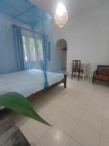 a bedroom with a bed with a blue canopy at Seaside Villa Talalla in Talalla +9 photos