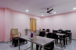 a dining room with tables and chairs and a ceiling fan at Hotel O Ss ome inn ultra luxury rooms in Ameerpet
