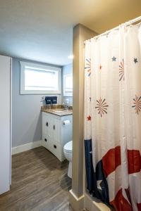 a bathroom with a toilet and a shower curtain at Blue Water Bungalows in Milford