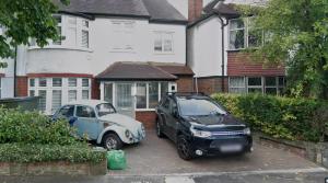 two cars parked in front of a house at The Cozy Nook in Hanwell