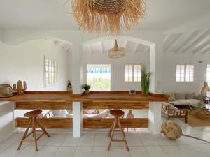 a living room with a wooden table and stools at Villa Cameo in Le Gosier
