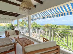 a room with a balcony with a view of the ocean at Villa Cameo in Le Gosier