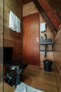 a bathroom with a black toilet and a sink at Chalé Encanto - Hotel Fazenda Gabro in Apiaí